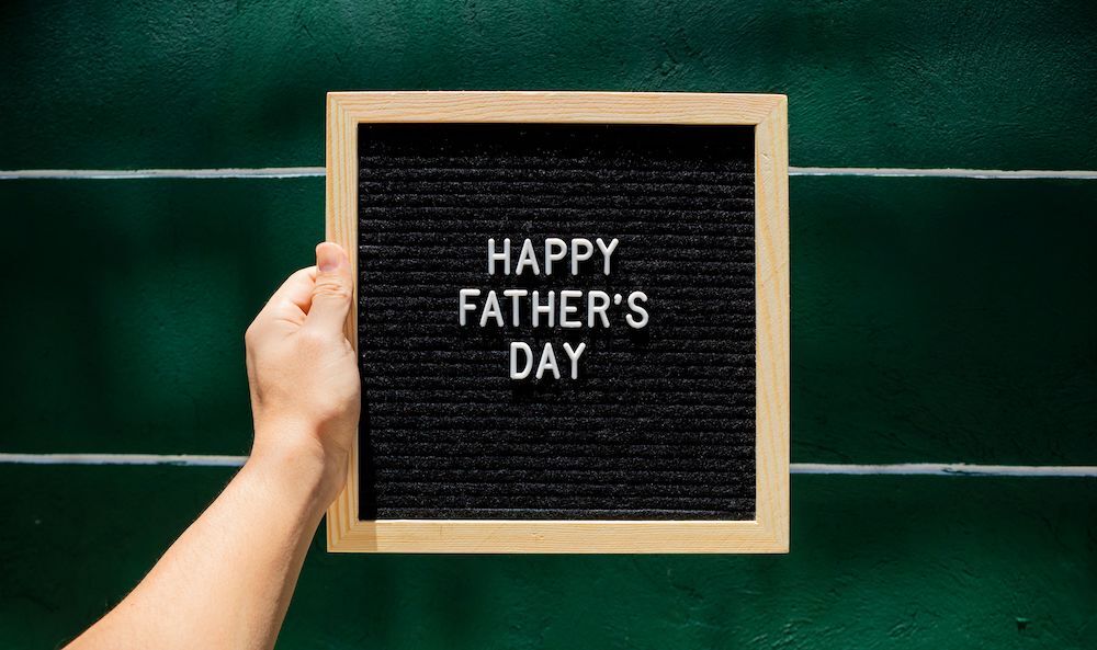 Happy Father's Day message in front of a green wall